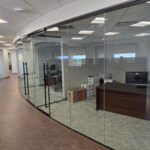 Curved glass-walled office corridor