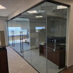 Glass-walled office with desk and city view