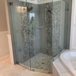 Glass-enclosed corner shower with mosaic tiles