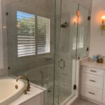 Glass shower enclosure and tub with brass fixtures