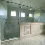 Glass-enclosed marble shower with three windows