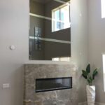 Modern fireplace with large mirror and plant