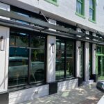 White storefront with green trim and awning