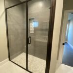 Black-framed glass shower with gray tile