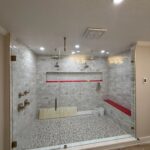 Glass-enclosed tiled walk-in shower under construction