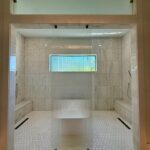 Spacious marble shower with ribbed glass panel