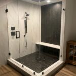 Modern glass shower with black hexagon tiles