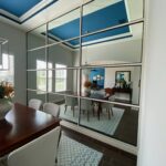 Dining room reflected in large grid mirror