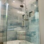 Glass shower with rain showerhead and bench