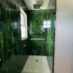 Walk-in shower with glossy green tiles