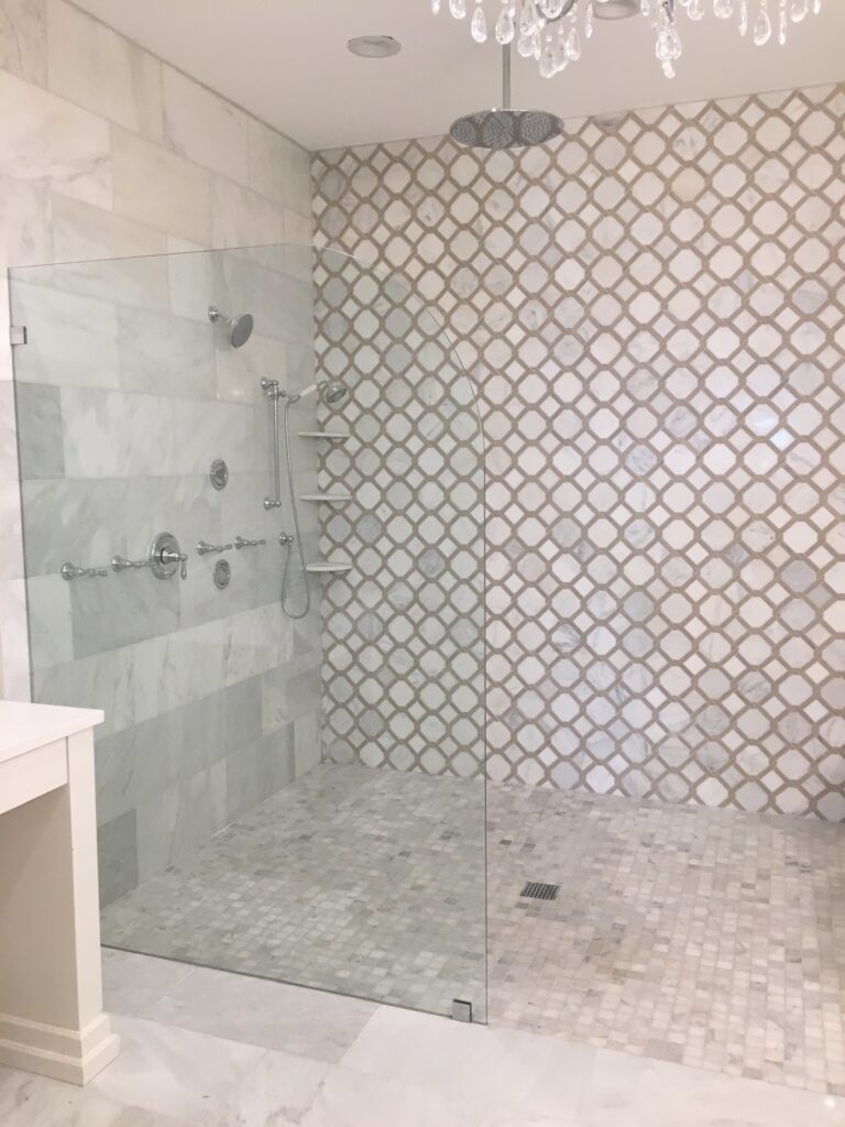 Glass-enclosed shower with patterned tile wall