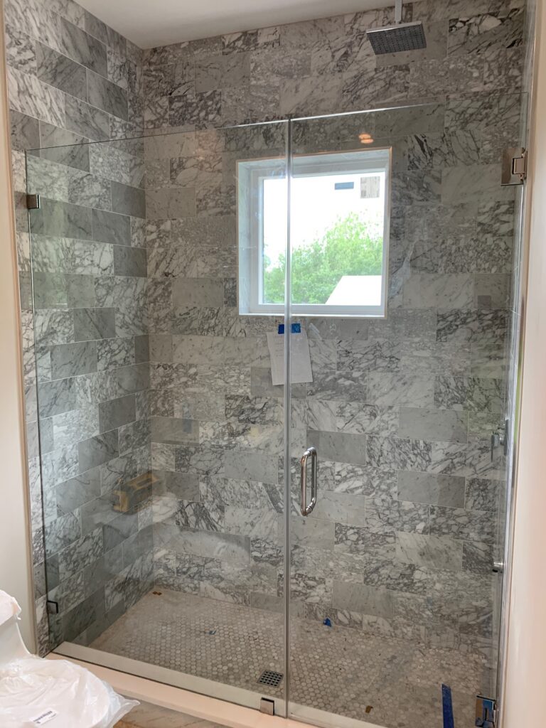 Marble tiled glass shower with window
