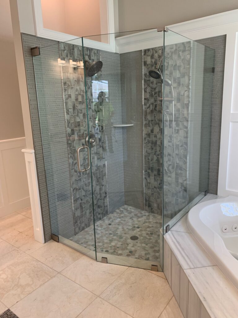 Frameless glass shower with gray mosaic tiles